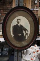 A VINTAGE OVAL FRAMED PHOTOGRAPHIC PRINT OF A MAN