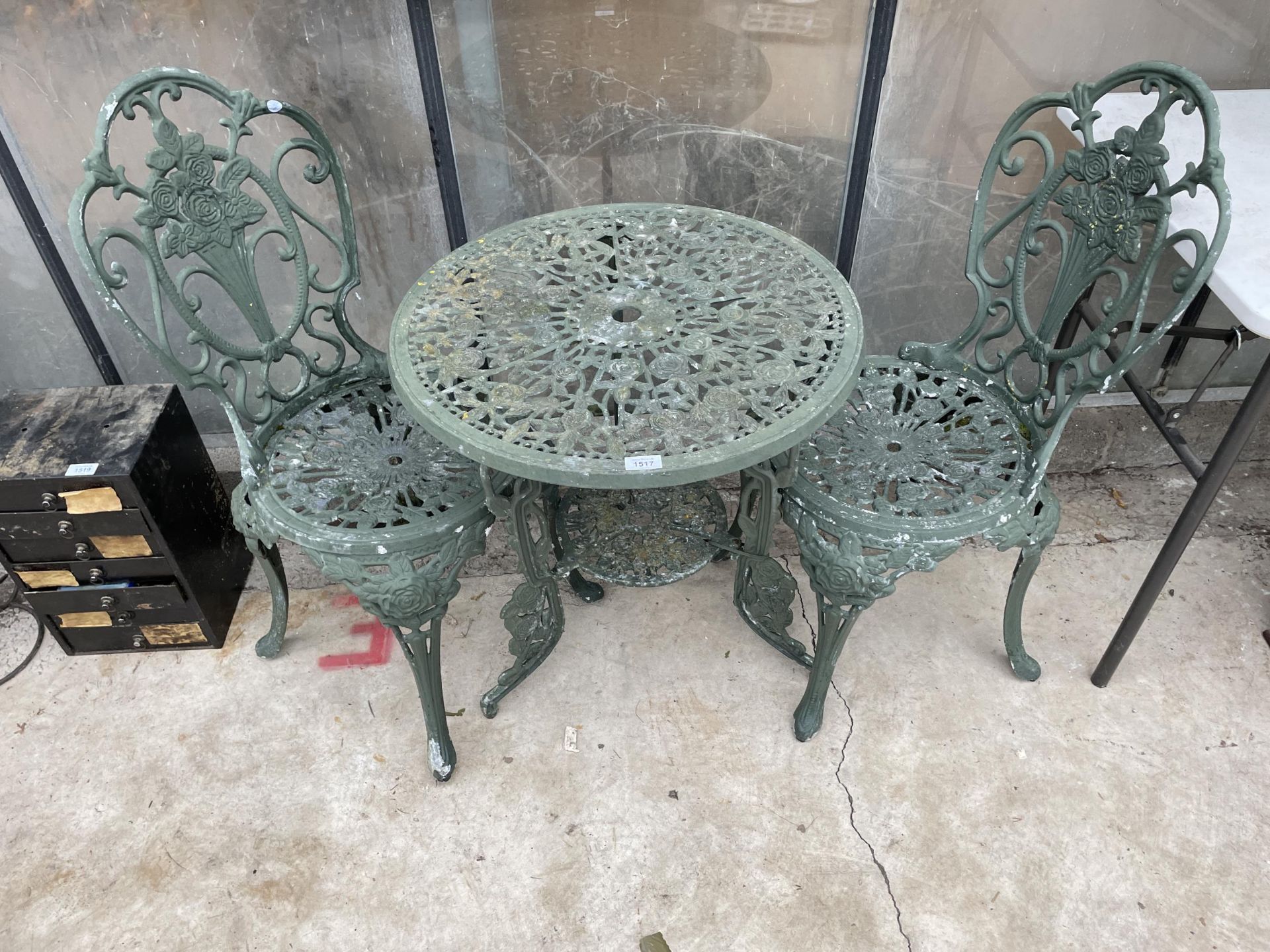 AN ALLOY BISTRO SET COMPRISING OF A ROUND TABLE AND TWO CHAIRS