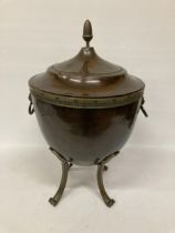 A BRASS AND COPPER COAL BOX ON FOUR LEGS, WITH LION HEAD HANDLES, AN ACORN TOP AND LINER