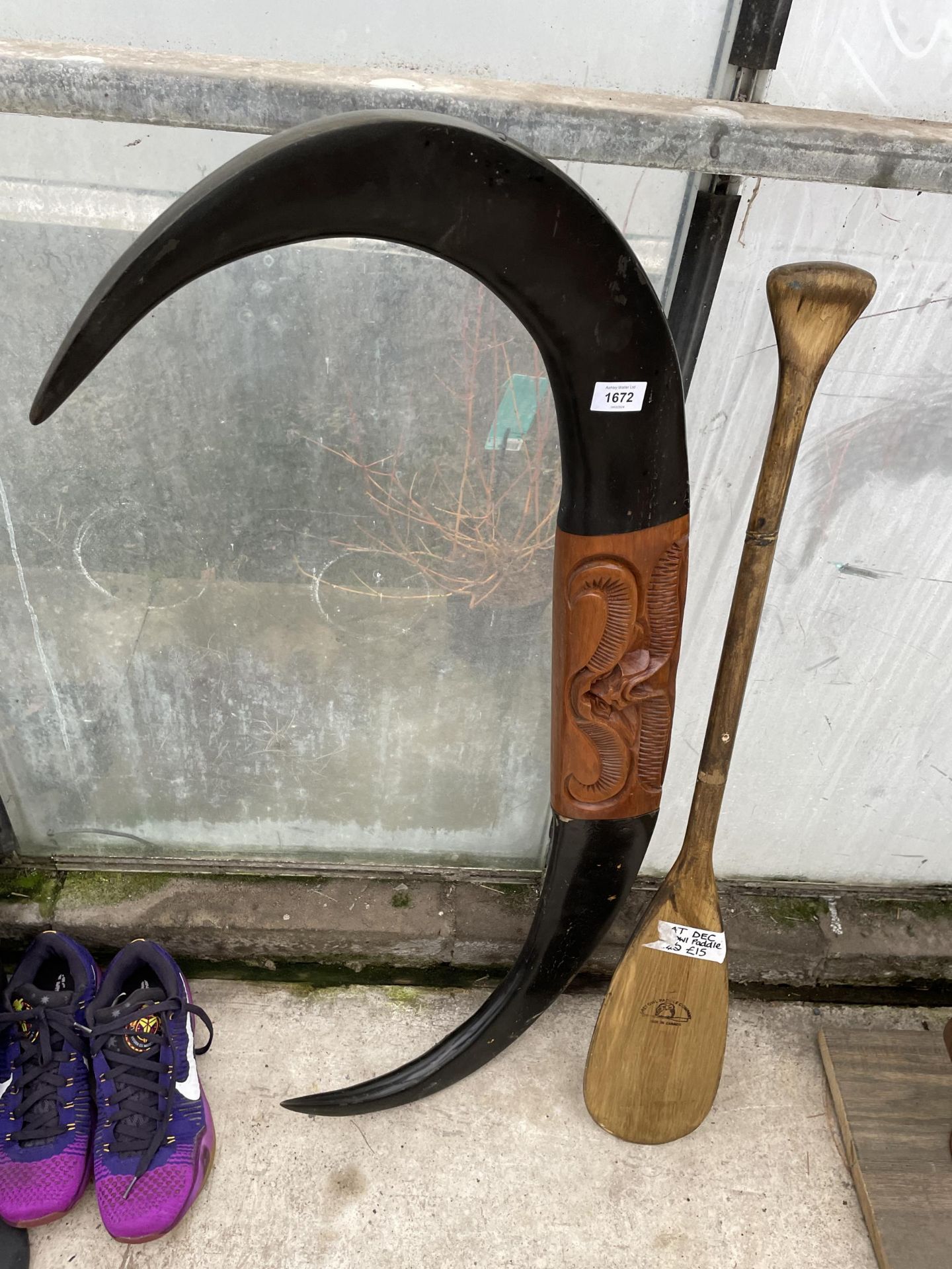 AWOODEN PADDLE AND A WOODEN PLAQUE IN THE FORM OF HORNS