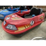 A RED BATTERY POWERED CHILDS BUMPER CAR