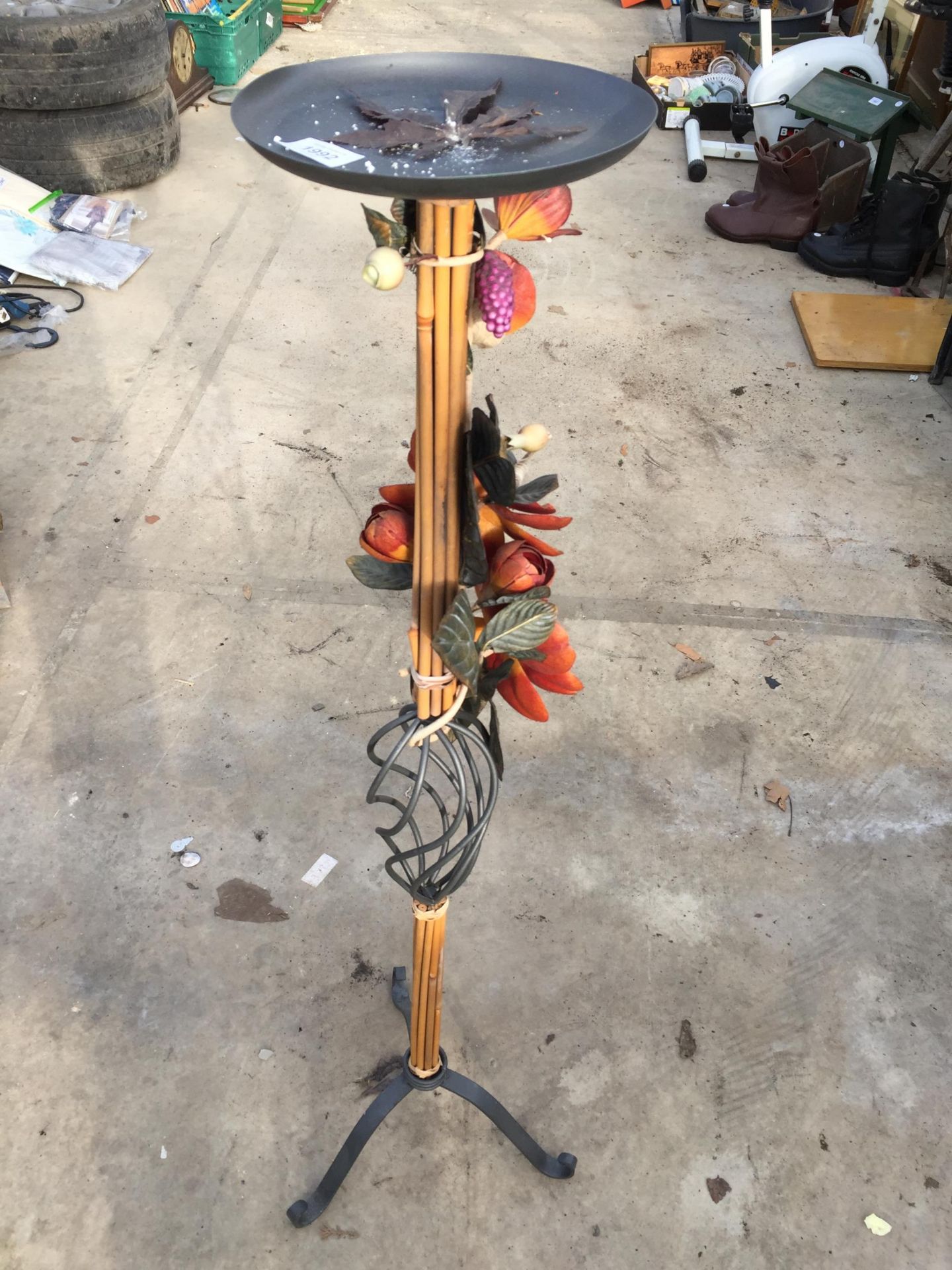 A TALL METAL AND CANE CANDLESTICK