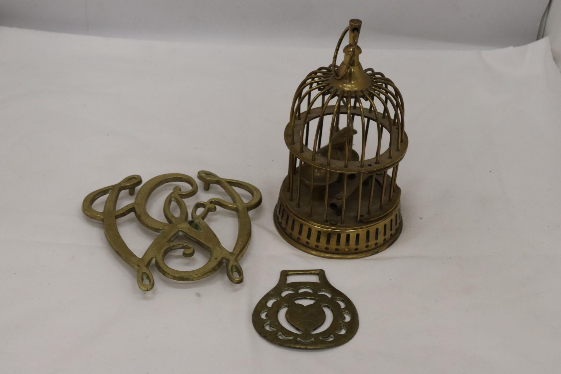 A BRASS BIRD IN A CAGE, HORSE BRASS AND STAND