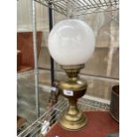 A VINTAGE BRASS OIL LAMP WITH WHITE GLASS SHADE AND CLEAR GLASS FUNNEL