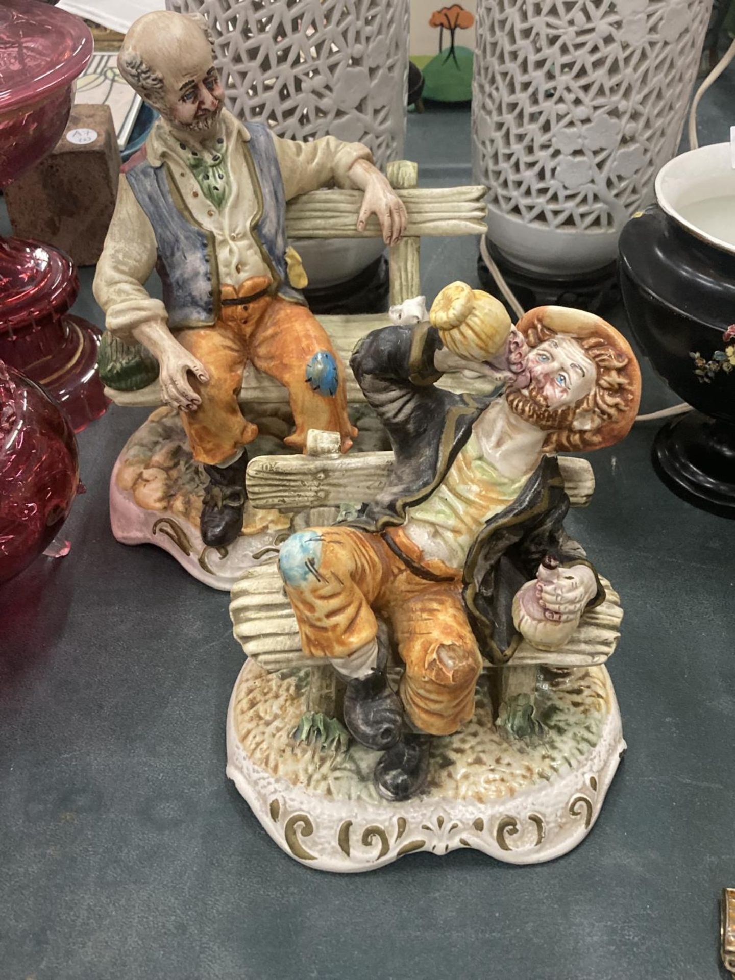 TWO CAPODIMONTE MODELS OF OLD MEN ON BENCHES