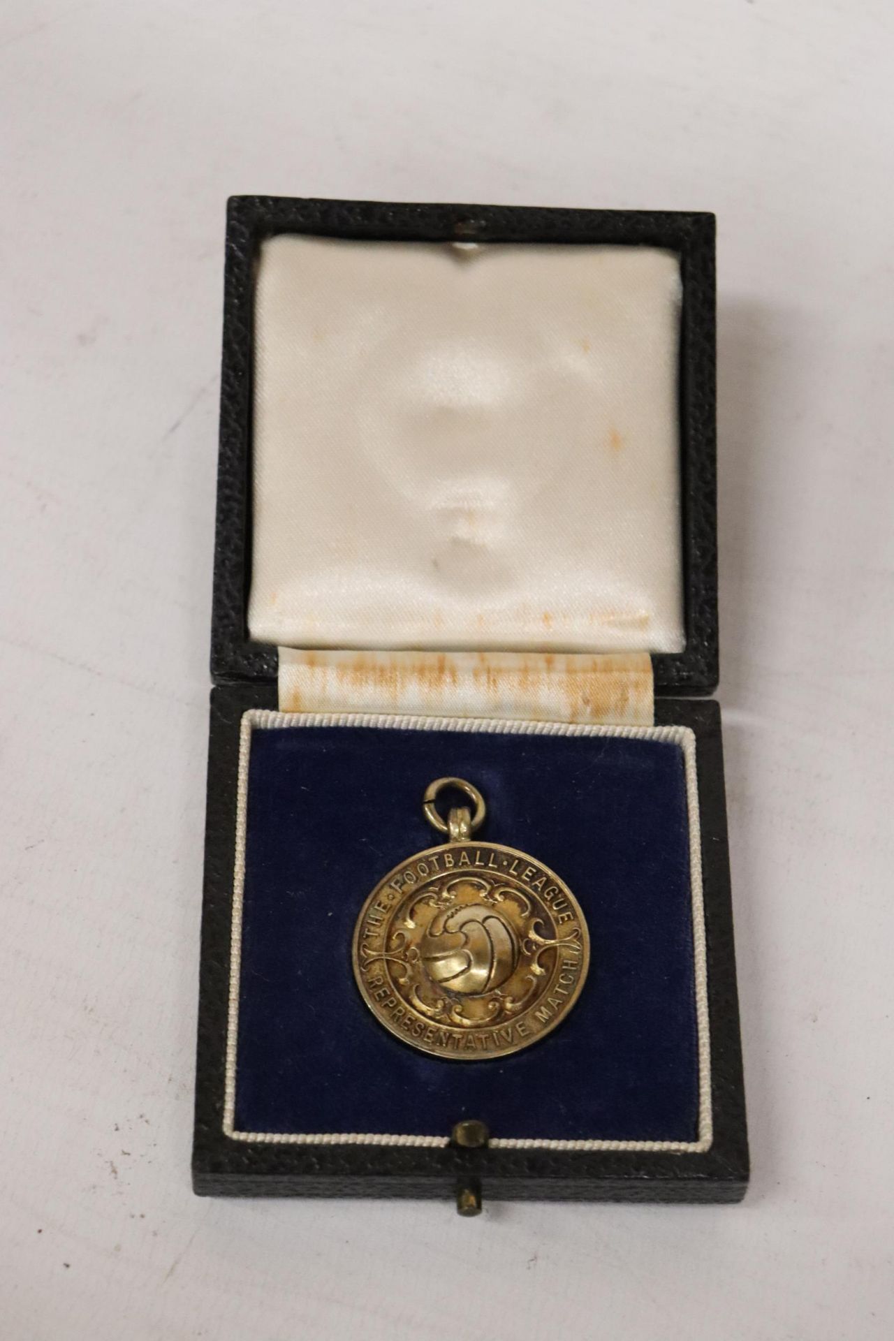 A BIRMINGHAM HALLMARKED SILVER 'THE FOOTBALL LEAGUE REPRESENTITIVE MATCH' MEDAL PRESENTED TO A