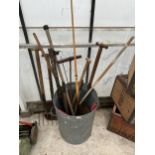 A GALVANISED DUSTBIN WITH AN ASSORTMENT OF GARDEN TOOLS TO INCLUDE SPADE, FORK AND SHEARS ETC