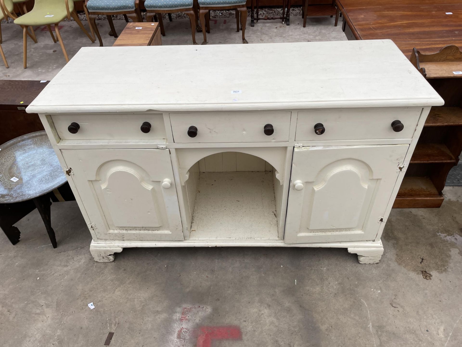 A VICTORIAN STYLE PINE KITCHEN DRESSER BASE ENCASING THREE DRAWERS, TWO CUPBOARDS AND AN OPEN