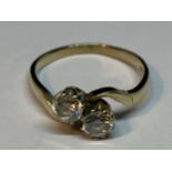 A 9 CARAT GOLD RING WITH TWO CUBIC ZIRCONIA STONES ON A TWIST SIZE K