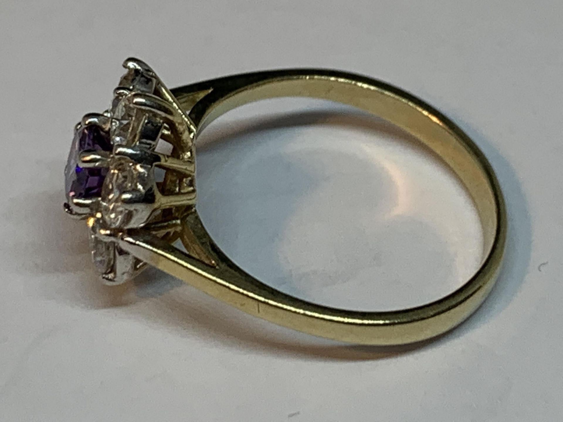 A 9 CARAT GOLD RING WITH CENTRE AMETHYST SURROUNDED BY CUBIC ZIRCONIAS IN A FLOWER DESIGN SIZE P/Q - Image 2 of 3