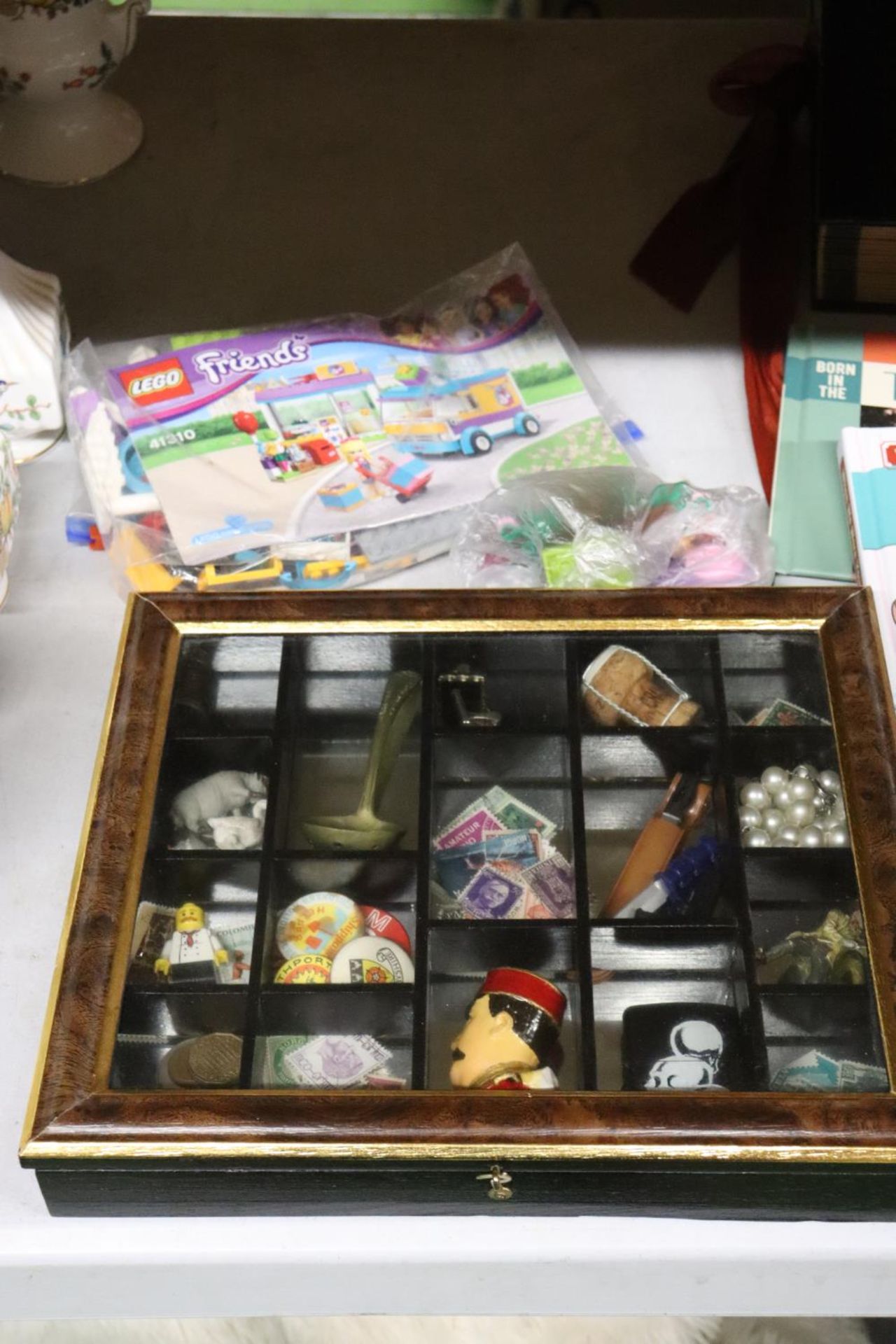 A SMALL DISPLAY CASE CONTAINING A QUANTITY OF COLLECTABLES