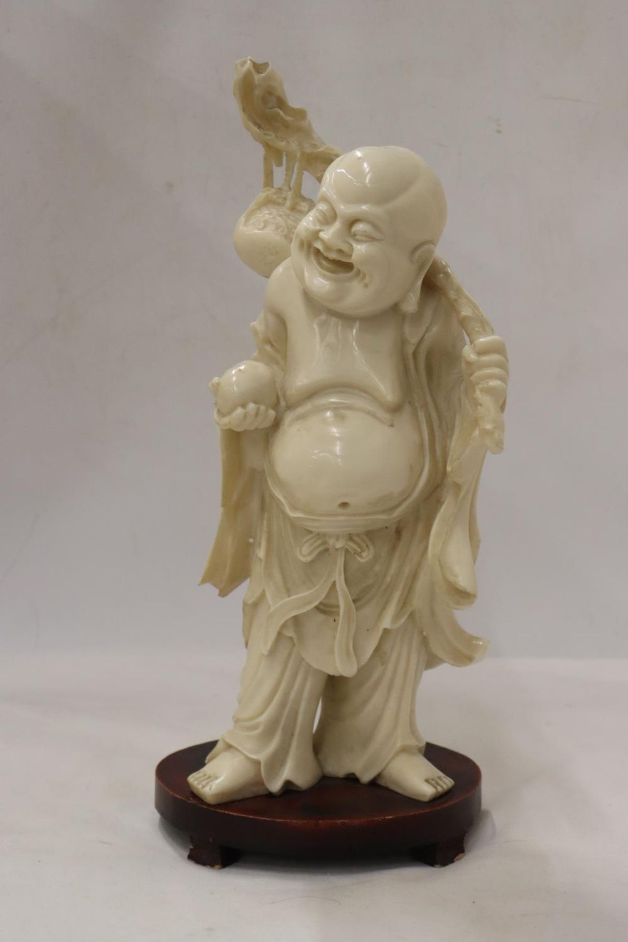 A CHINESE SCULPTURE FIGURINE ON WOODEN STAND