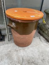 A GLAZED CLAY POT WITH WOODEN LID