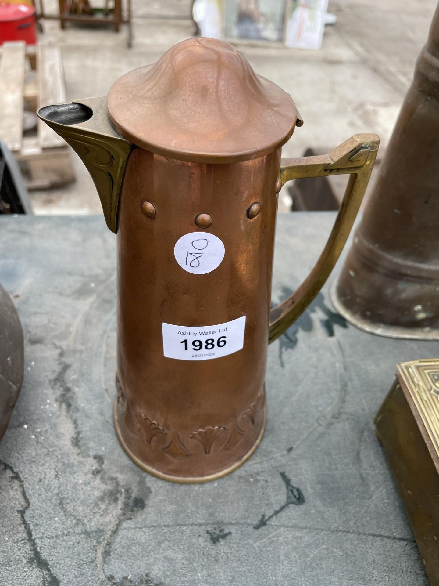 A SMALL COPPER AND BRASS LIDDED JUG