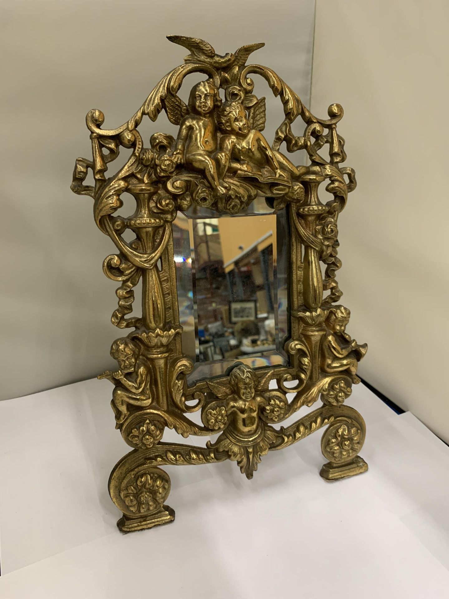 A MIRROR WITH A HEAVY BRASS DECORATIVE FRAME HEIGHT 36CM