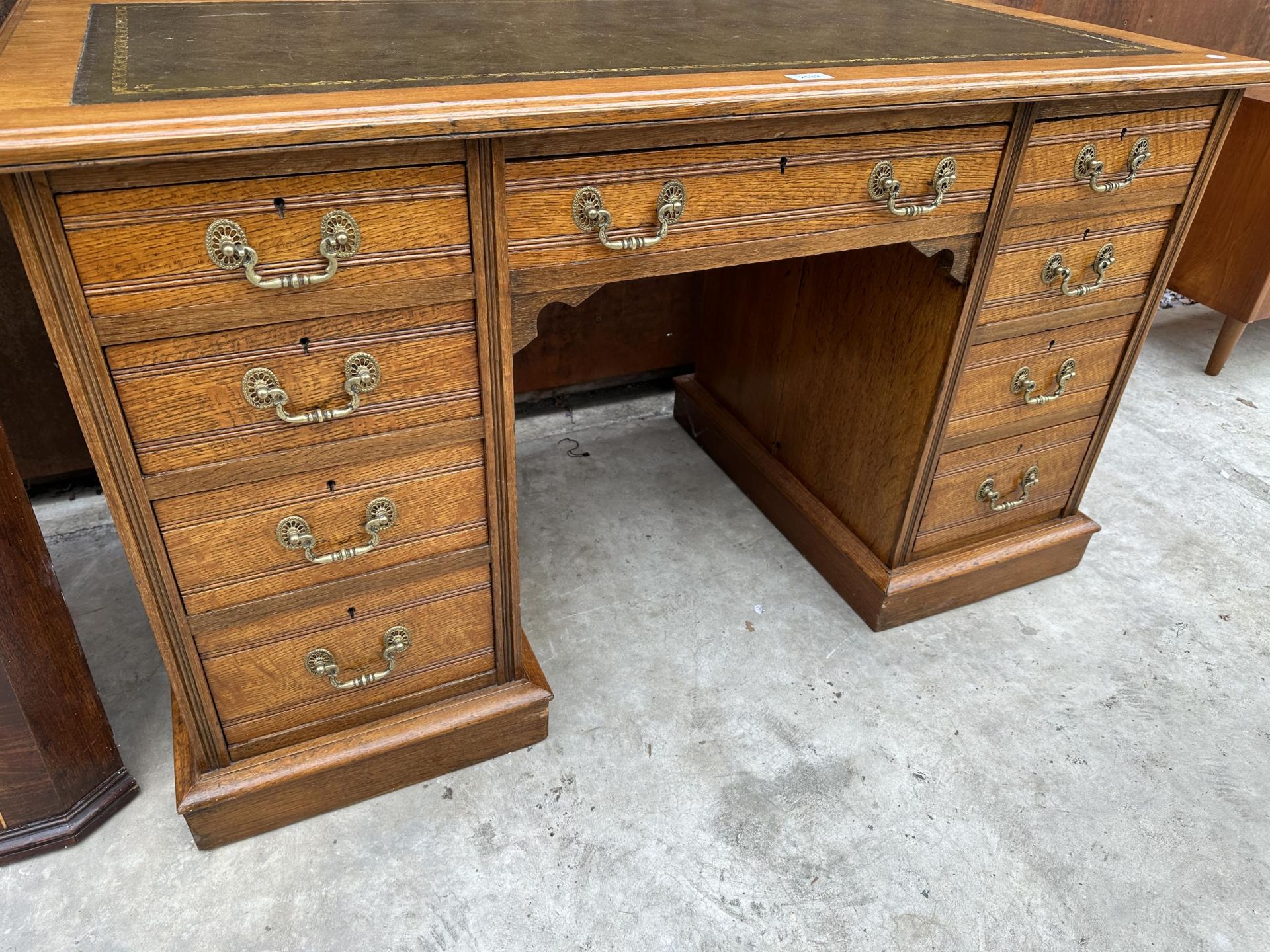 AN EDWARDIAN OAK TWIN PEDESTAL KNEE HOLE DESK ENCLOSING NINE DRAWERS WITH INSET LEATHER TOP 48" X - Image 3 of 4