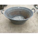 A SMALL OVAL GALVANISED TIN BATH