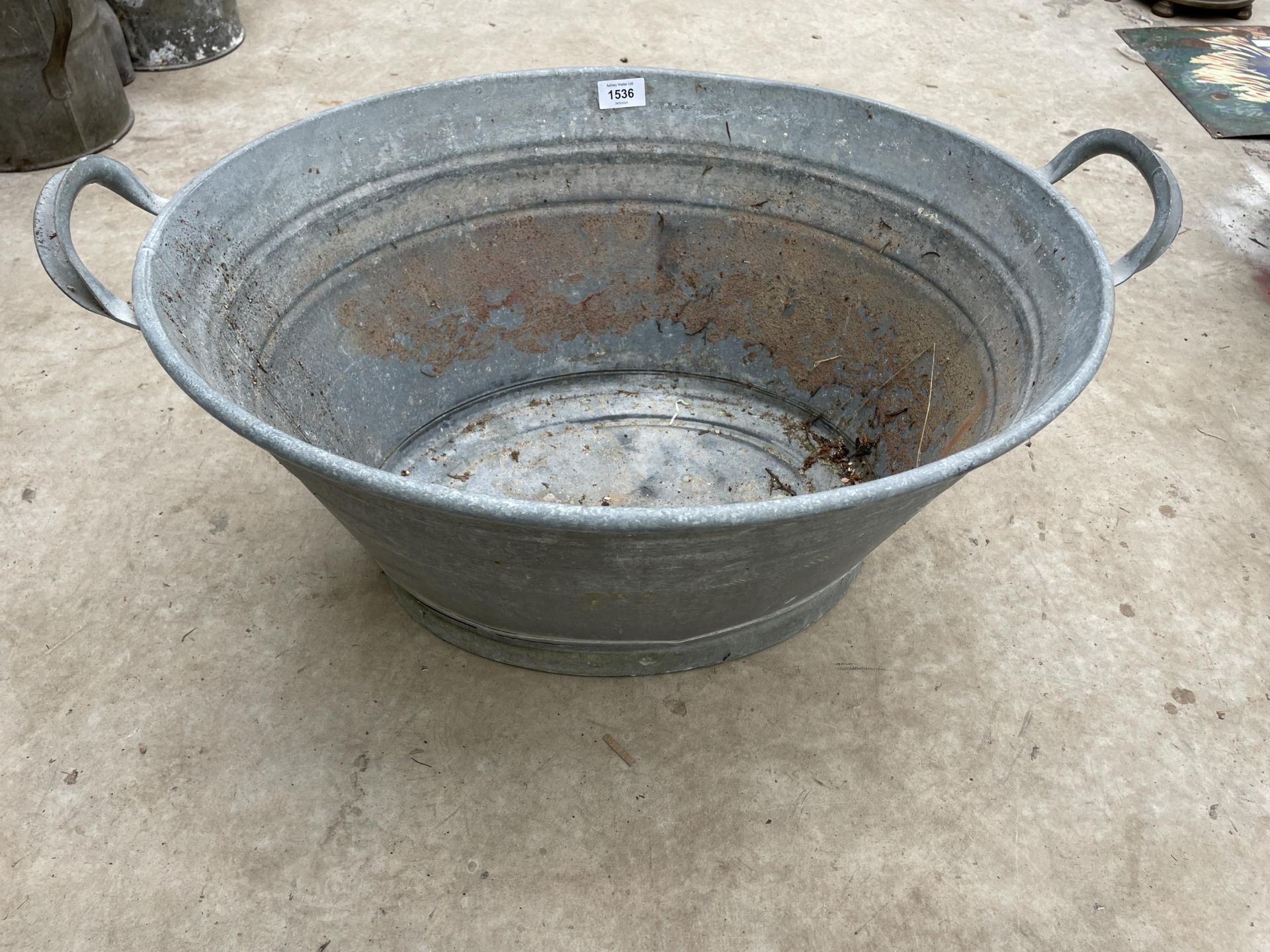 A SMALL OVAL GALVANISED TIN BATH