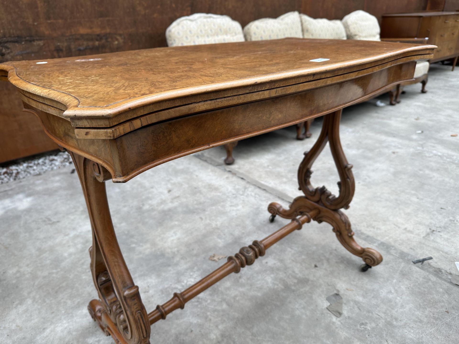 A VICTORIAN WALNUT FOLD OVER GAMES TABLE WITH LYRE SUPPORTS AND TURNED STRETCHER ON BRASS CASTERS - Image 3 of 6