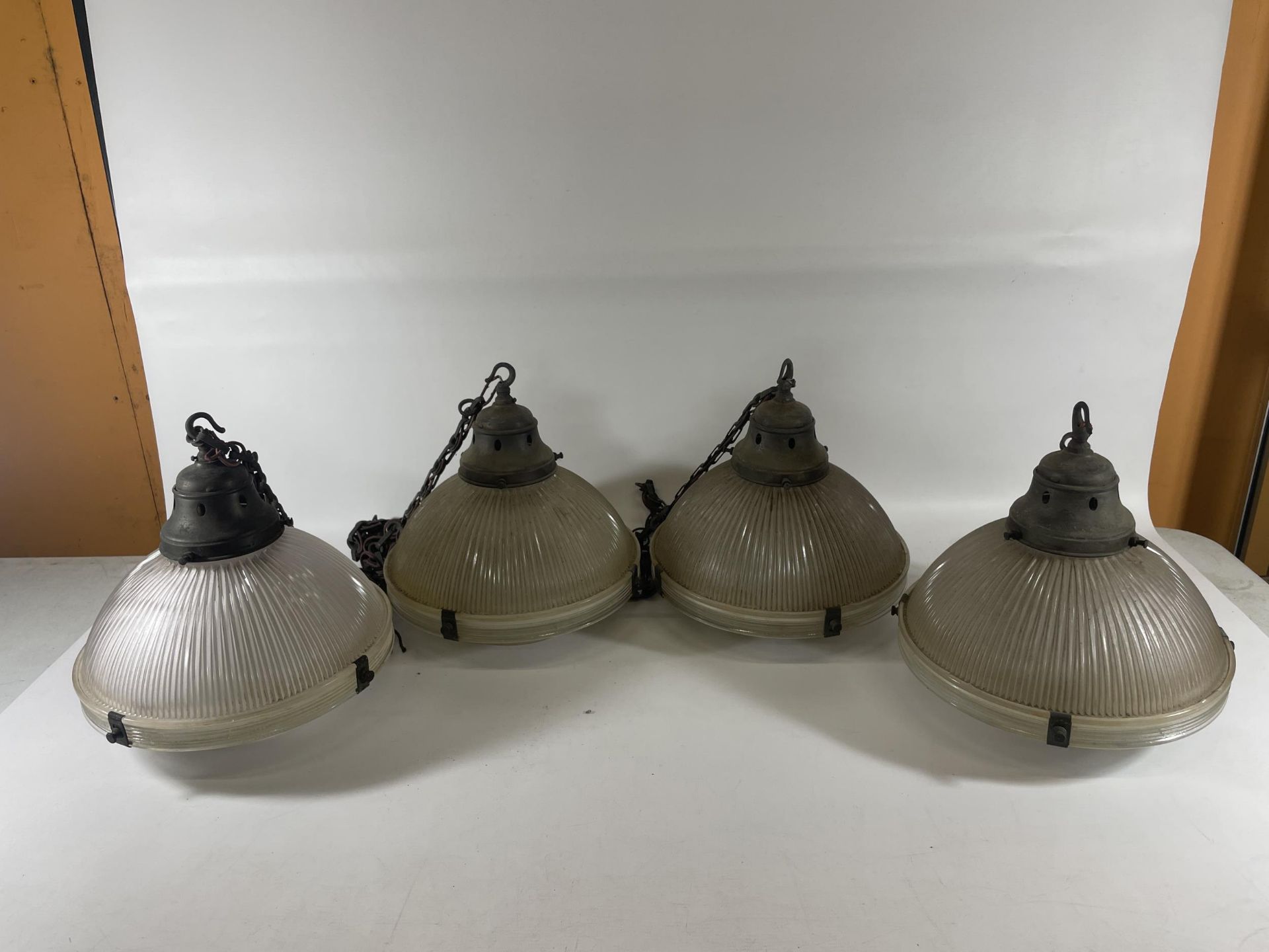 A SET OF FOUR VINTAGE HOLOPHANE 5 LAMPS WITH METAL FITTINGS AND CHAINS