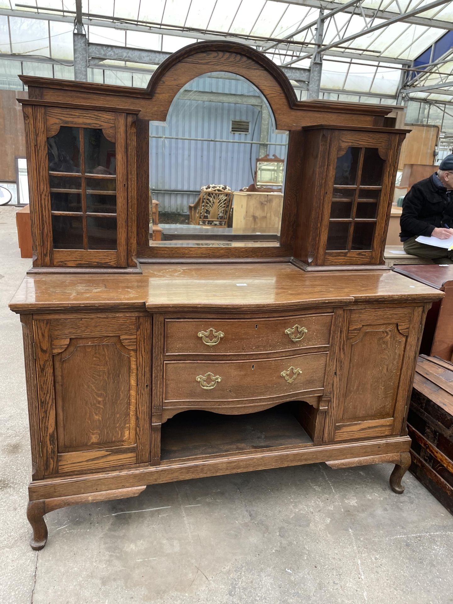 AN EDWARDIAN OAK MIRROR-BACK SIDEBOARD ENCLOSING TWO GLAZED CUPBOARDS TO UPPER PORTION - 60 INCH