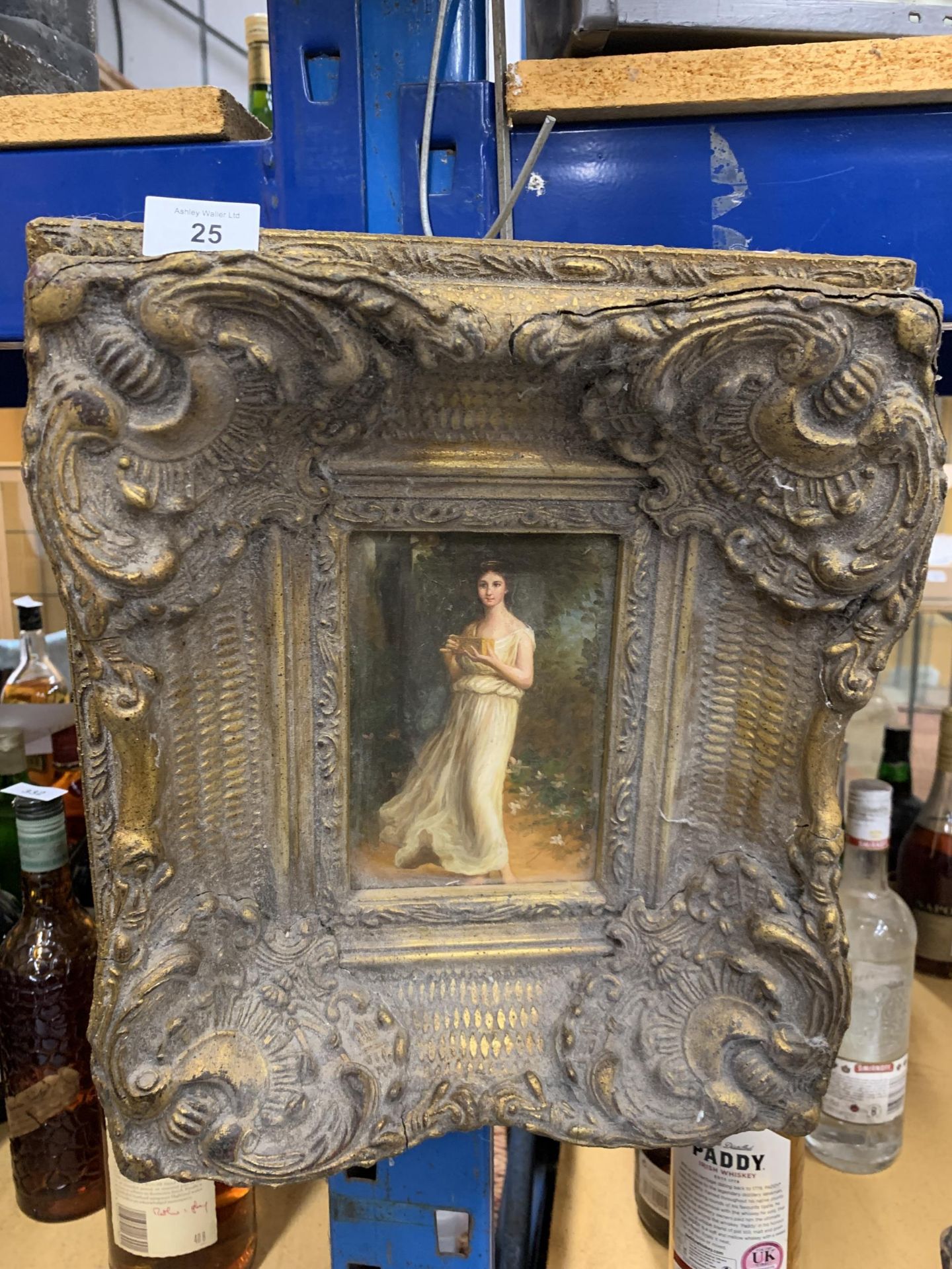 A HEAVY GILT FRAMED PAINTING OF A YOUNG GIRL WITH A GIFT BOX