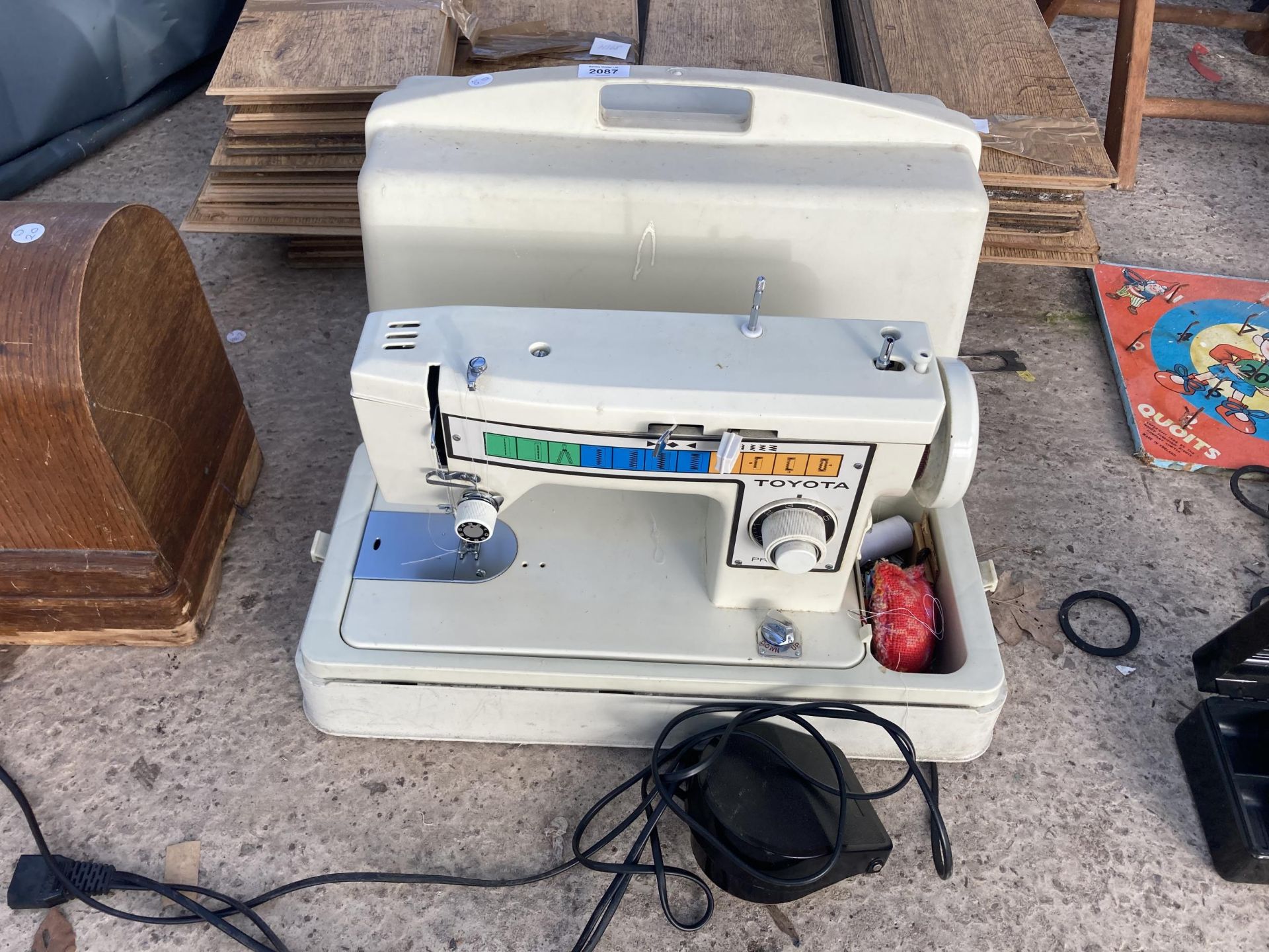A TOYOTA ELECTRIC SEWING MACHINE WITH FOOT PEDAL AND CARRY CASE