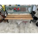 A WOODEN SLATTED GARDEN BENCH WITH DECORATIVE CAST BENCH ENDS