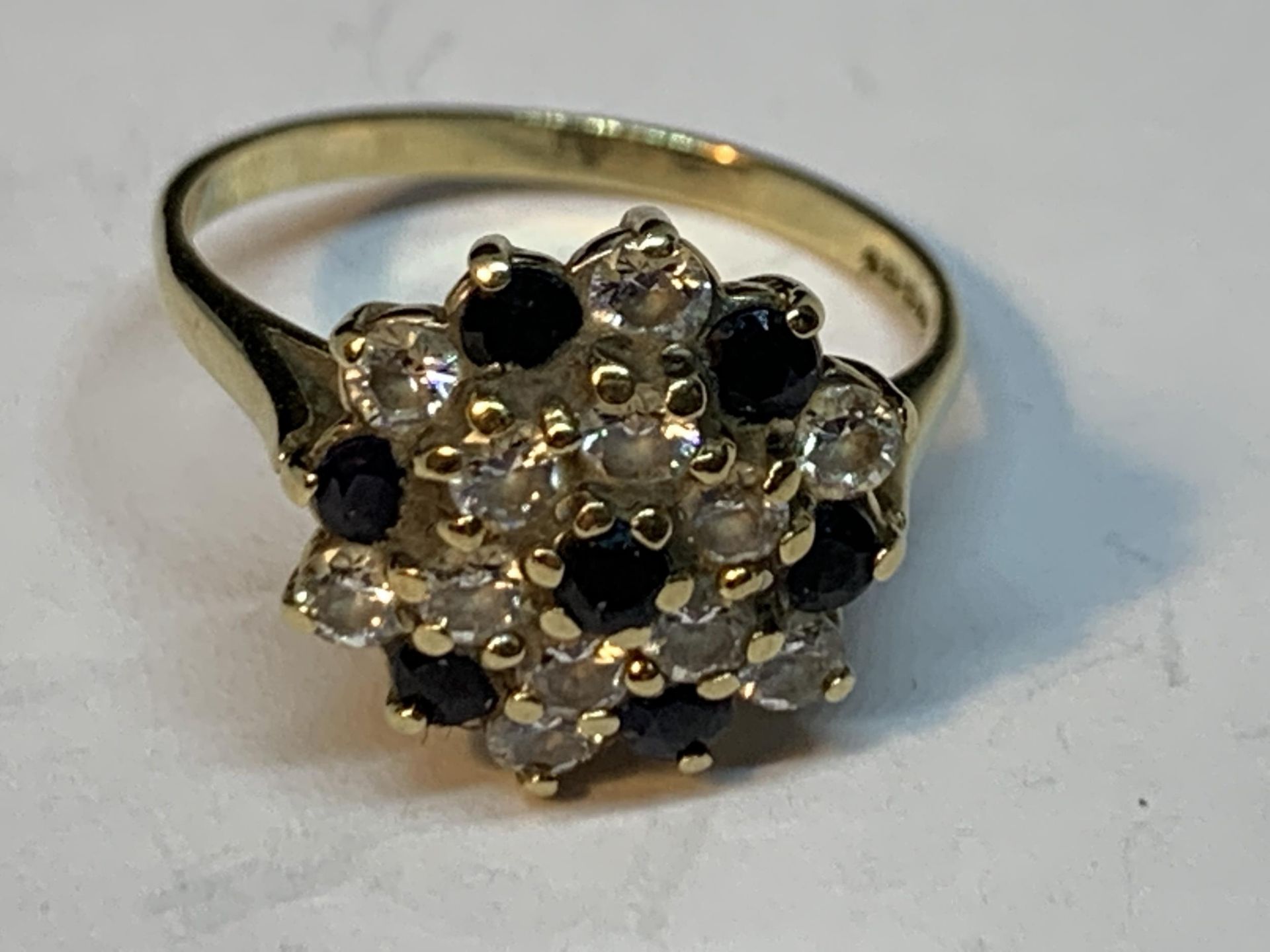 A 9 CARAT GOLD RING WITH A CLUSTER OF SAPPHIRES AND CUBIC ZIRCONIAS SIZE N/O