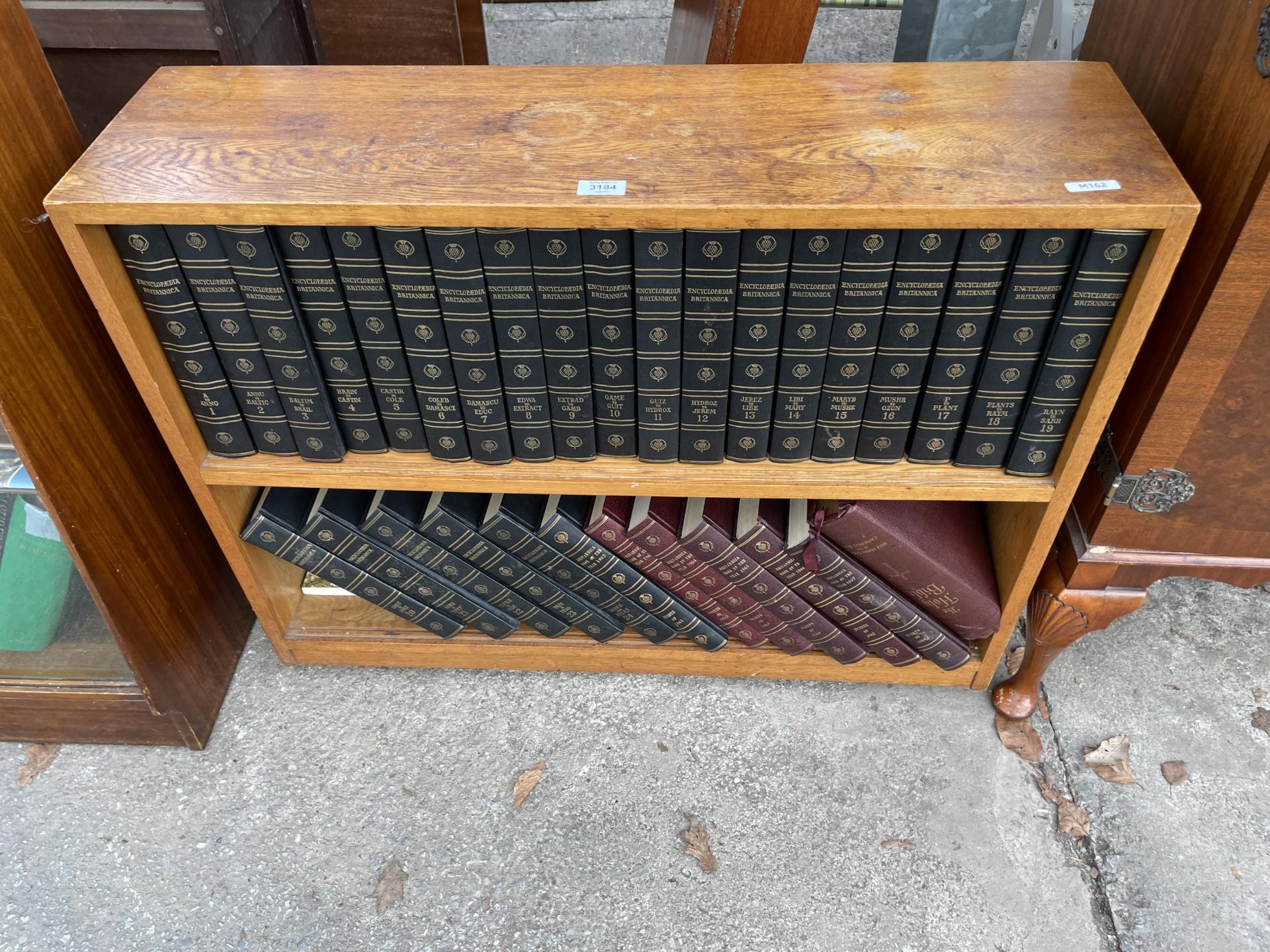 AN OAK OPEN BOOKCASE CONTAINING ENCYCLOPEDIAS 36" WIDE