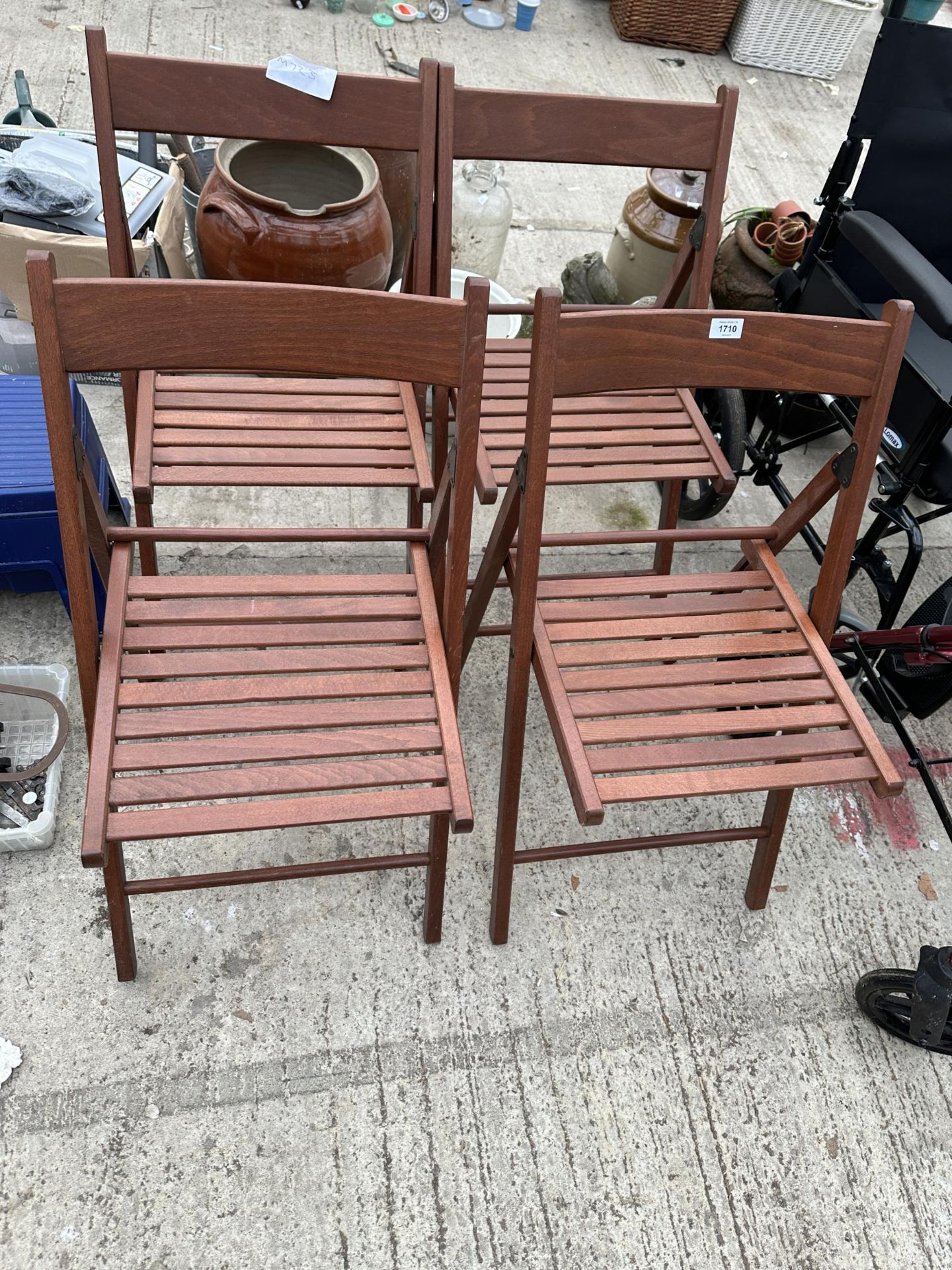 A SET OF FOUR TEAK FOLDING GARDEN CHAIRS