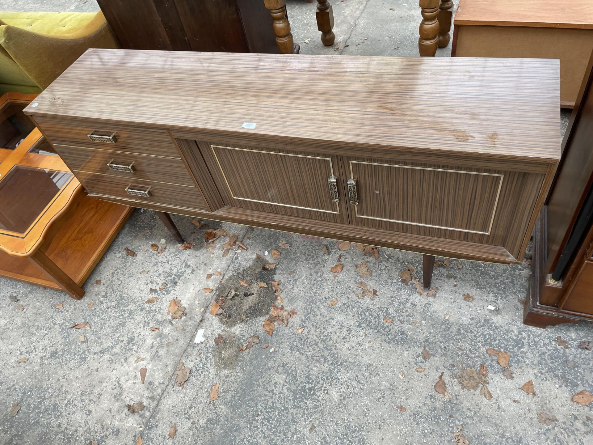 A RETRO LAMINATE WOOD EFFECT SIDEBOARD ENCLOSING THREE DRAWERS AND TWO CUPBOARDS - 66 INCH WIDE