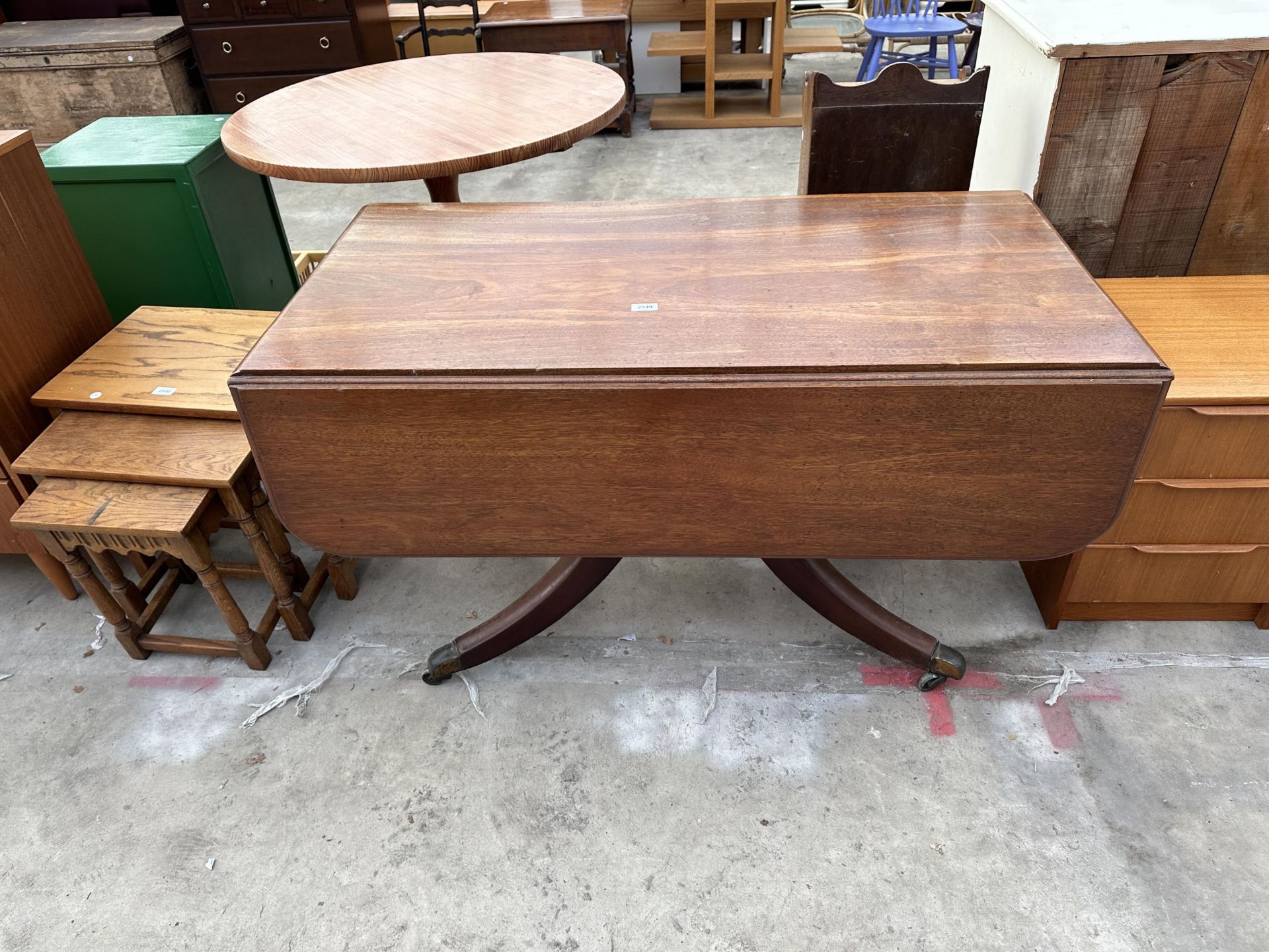 A 19TH CENTURY MAHOGANY PEDESTAL DROP LEAF TABLE WITH BRASS CASTERS 48" SQUARE OPENER