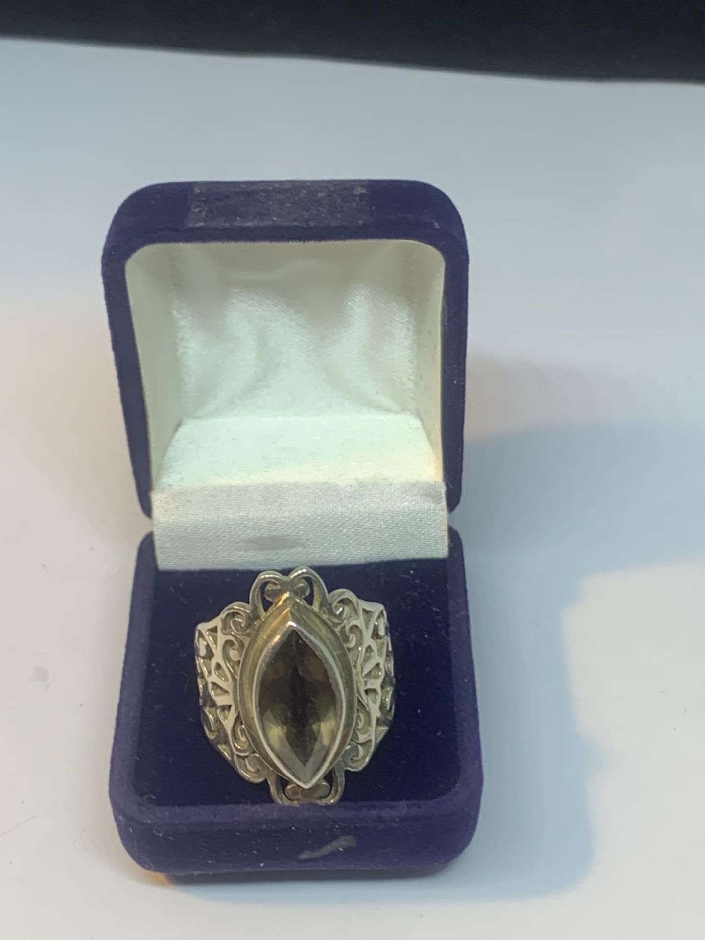 A SILVER DRESS RING WITH A SMOKEY STONE IN A PRESENTATION BOX