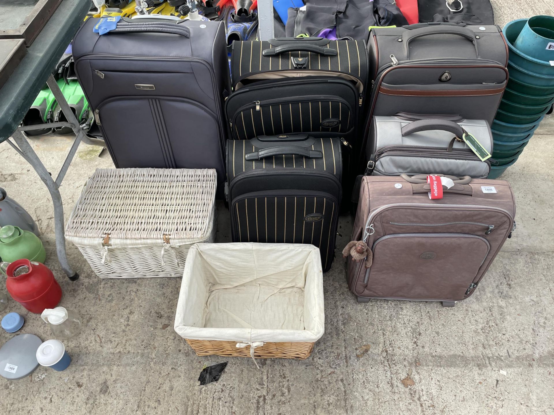 AN ASSORTMENT OF SUITCASES AND WICKER BASKETS ETC