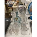 A QUANTITY OF GLASS BOTTLES SOME WITH STOPPERS AND DECANTERS