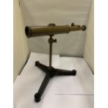 A VINTAGE BRASS TELESCOPE ON A CAST TRIPOD STAND