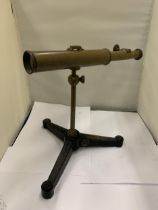 A VINTAGE BRASS TELESCOPE ON A CAST TRIPOD STAND