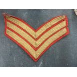 A RED AND GOLD, SERGEANTS STRIPES, CLOTH BADGE