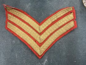 A RED AND GOLD, SERGEANTS STRIPES, CLOTH BADGE