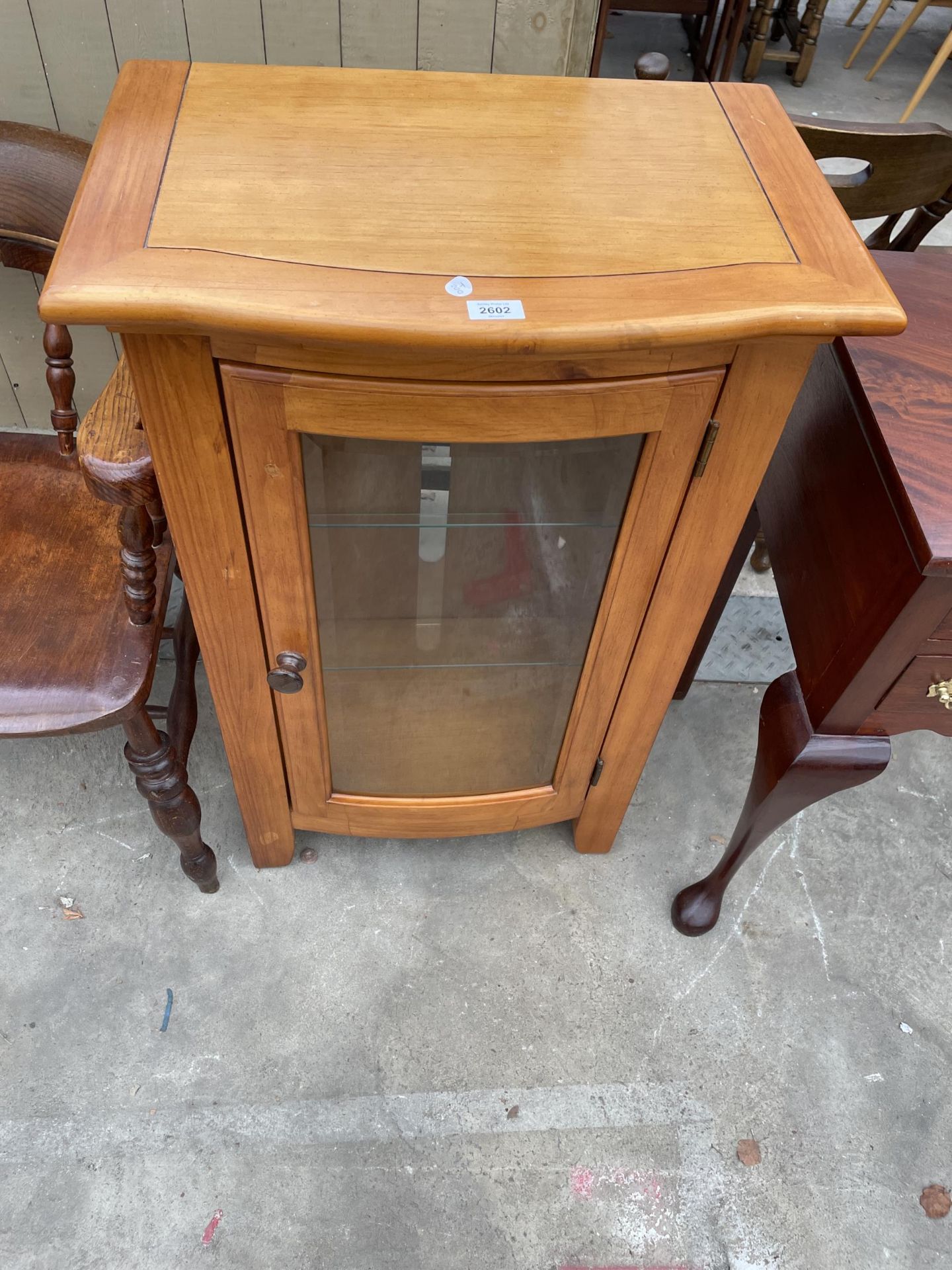 A BOW FRONTED CABINET WITH GLASS DOOR 24" WIDE