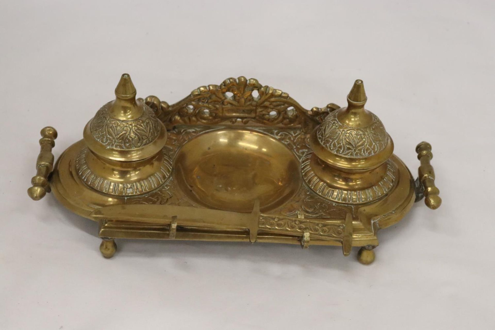 AN ORNATE BRASS INKWELL AND LETTER OPENER