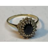 A 9 CARAT GOLD RING WITH A CENTRE SAPPHIRE SURROUNDED BY DIAMONDS SIZE S