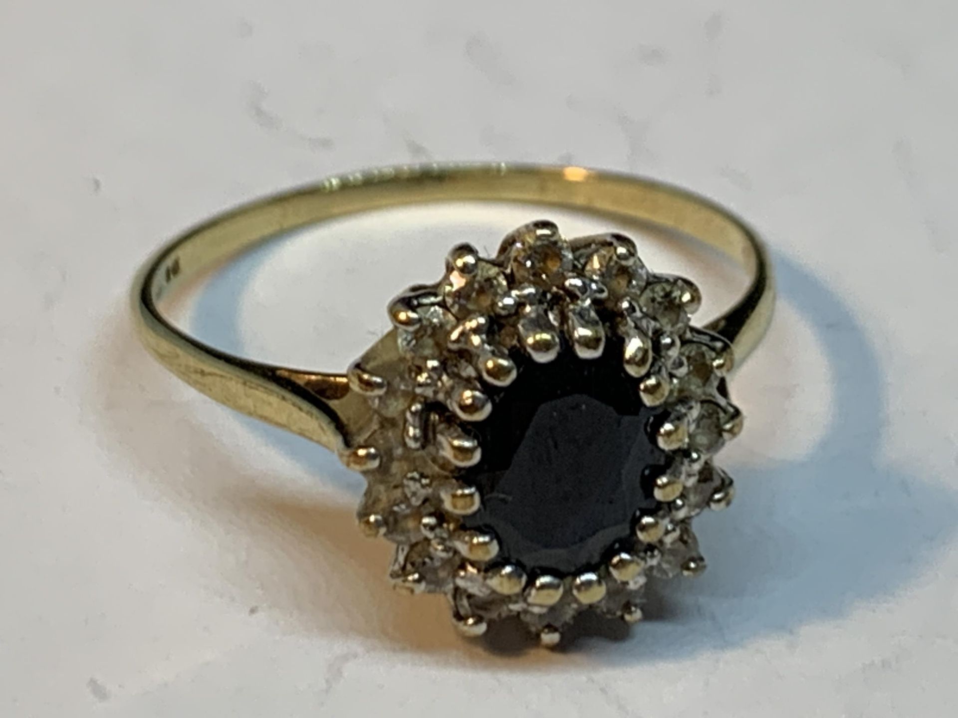 A 9 CARAT GOLD RING WITH A CENTRE SAPPHIRE SURROUNDED BY DIAMONDS SIZE S