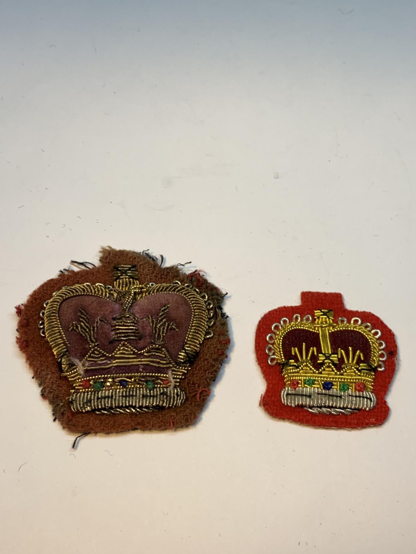 TWO BEAD AND CLOTH CROWN BADGES