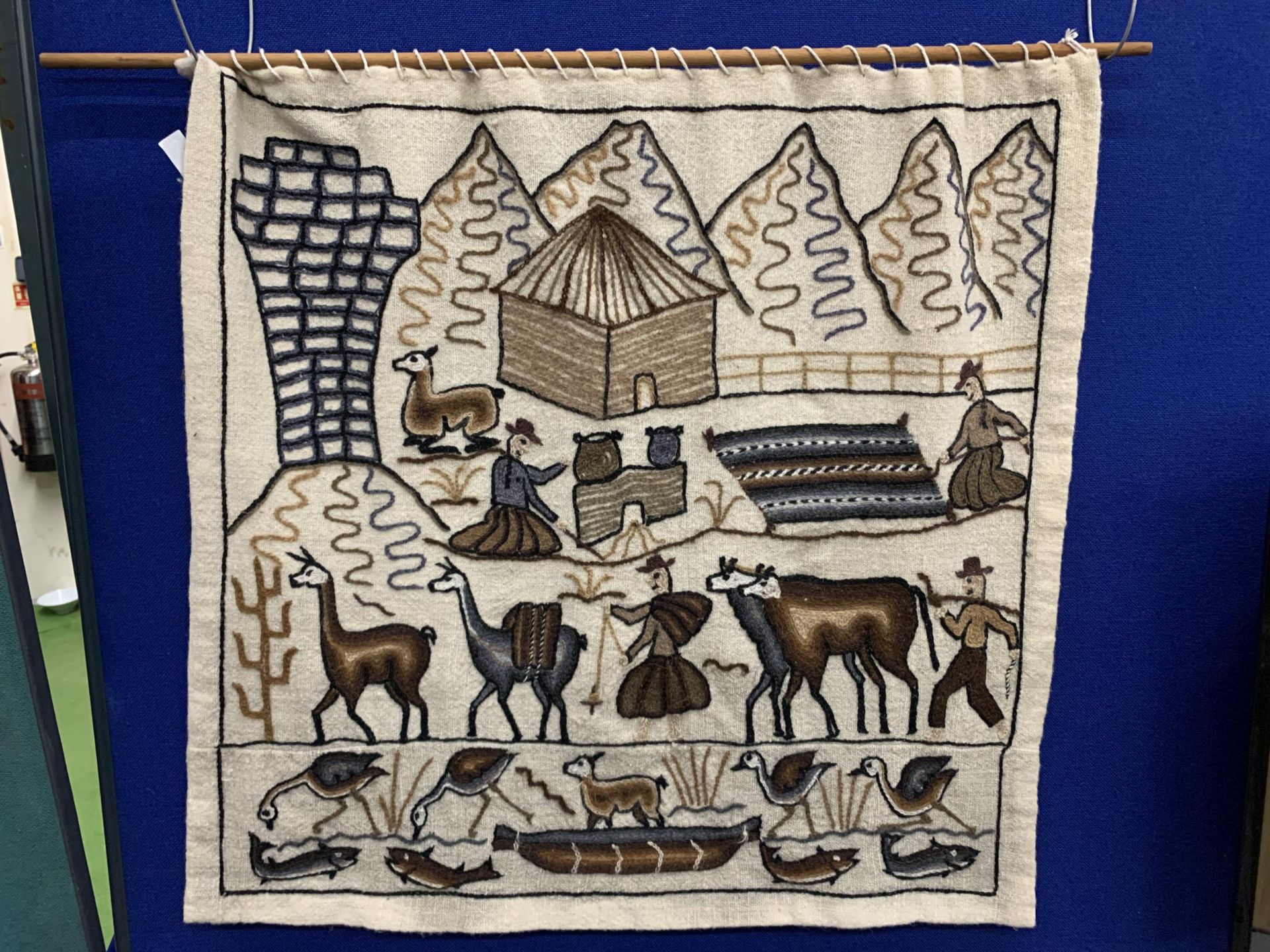 A NAIVE WOOLWORK WALL HANGING WITH ANIMALS, FIGURES AND MOUNTAINS, APPROX 84CM X 80CM