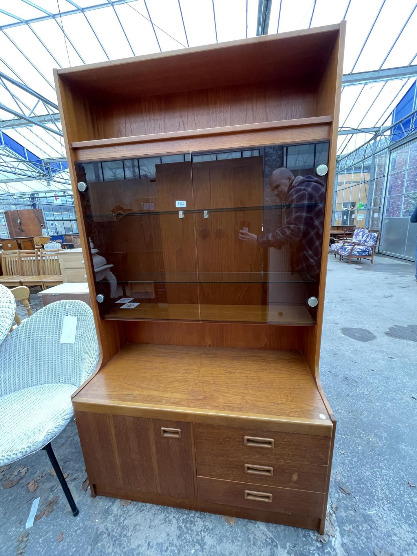 A RETRO TEAK LOUNGE UNIT WITH SMOKED GLASS DOORS, CUPBOARD AND DRAWERS TO BASE. 39.5" WIDE