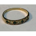 A 9 CARAT GOLD RING WITH FOUR EMERALDS AND THREE CUBIC ZIRCONIAS IN A LINE SIZE Q/R