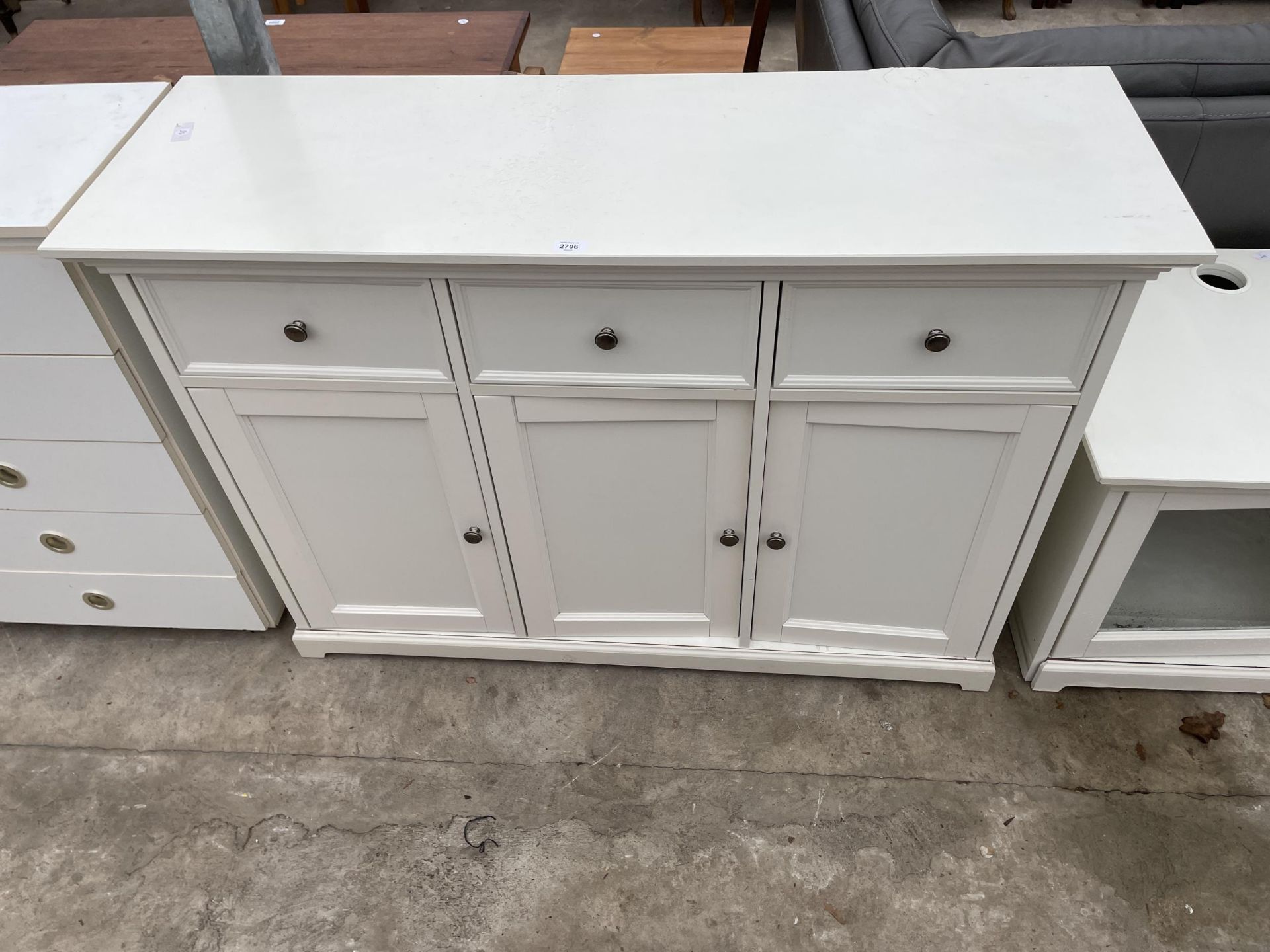 A MODERN WHITE SIDEBOARD ENCLOSING THREE DRAWERS AND THREE CUPBOARDS - 51.5 INH WIDE