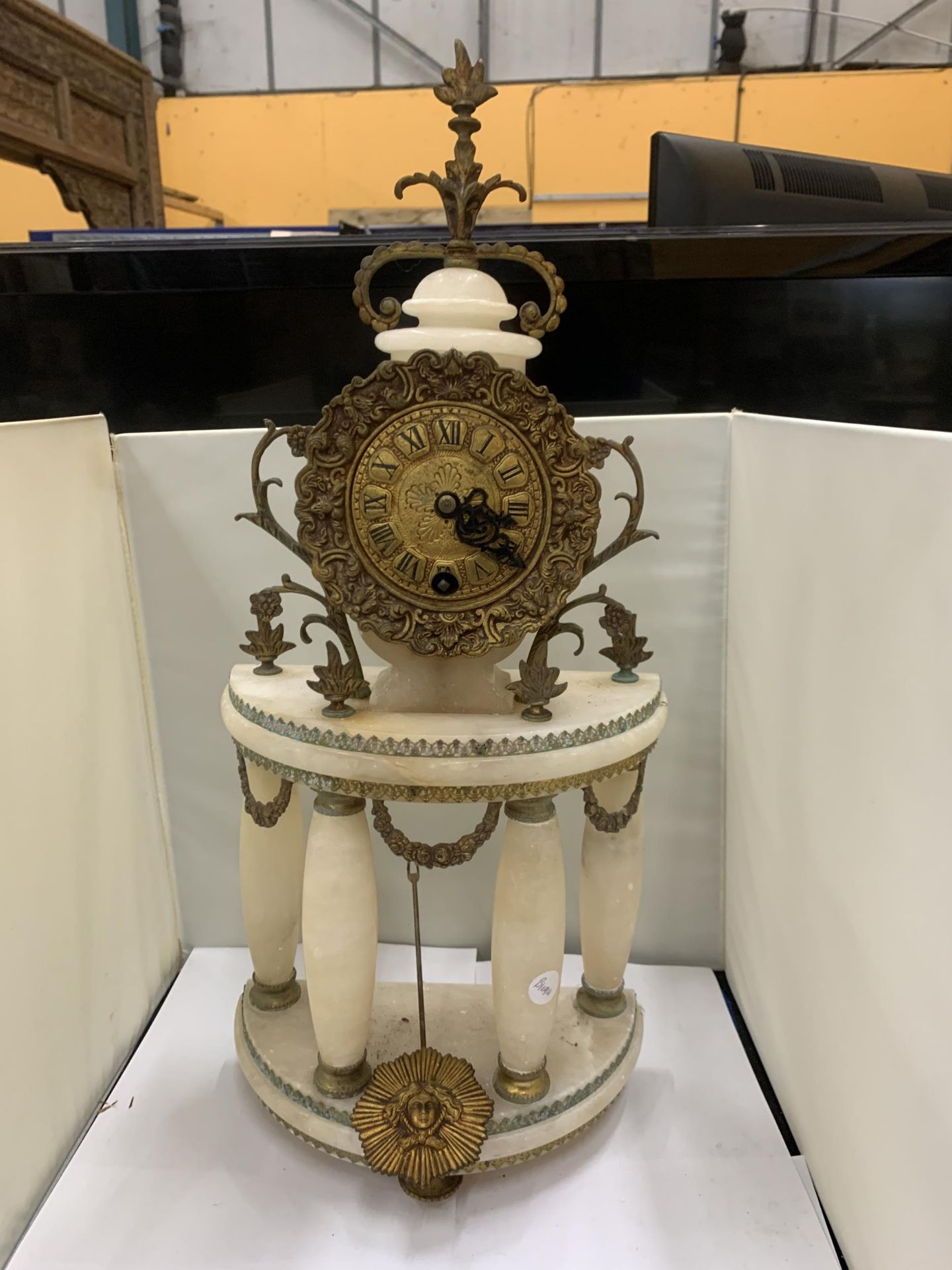 A PORTICO CLOCK LOUIS XVI STYLE IN WHITE MARBLE WITH GILDED BRONZE. A HALF MOON SHAPED PORTICO